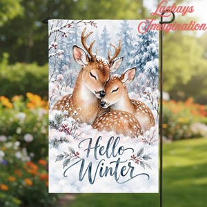 May include: A rectangular garden flag featuring two brown deer with white spots resting in a snowy forest. The deer have their eyes closed and are nestled together. The text Hello Winter is printed in blue script below the deer.