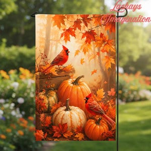 May include: A rectangular garden flag featuring a vibrant autumn scene with two bright red cardinals perched near orange and white pumpkins. The background displays a forest filled with golden and orange maple leaves, creating a warm seasonal display.