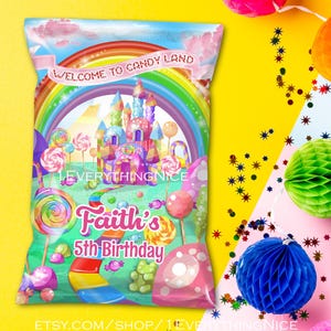 May include: A colorful candy-themed party favor bag with a rainbow, castle, and lollipops. The bag reads "Welcome to Candy Land" and "Faith's 5th Birthday". The background is yellow with decorative paper balls.