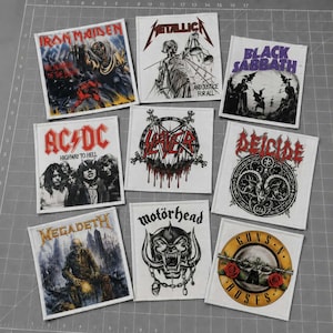 May include: A collection of nine square fabric patches featuring various heavy metal and rock band logos and album art, including Iron Maiden, Metallica, Black Sabbath, AC/DC, Slayer, Deicide, Megadeth, Motörhead, and Guns N' Roses on white backgrounds.