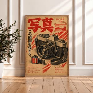 May include: A vintage-style poster featuring a detailed illustration of a 35mm film camera and a film canister. The design includes bold red Japanese text, a landscape graphic, and technical specifications printed on a textured, tan-colored background.