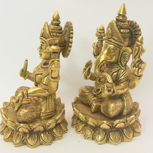 Peut inclure: Une paire de statues en m&eacute;tal dor&eacute; repr&eacute;sentant les divinit&eacute;s hindoues Ganesha et Lakshmi, assises sur des bases de fleurs de lotus. Les statues sont finement d&eacute;taill&eacute;es et pr&eacute;sentent un style indien traditionnel.