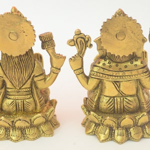 Peut inclure: Deux statues en m&eacute;tal dor&eacute; repr&eacute;sentant les divinit&eacute;s hindoues Lakshmi et Ganesha, assises sur des bases de lotus. Les statues sont finement d&eacute;taill&eacute;es et pr&eacute;sentent un style indien traditionnel.