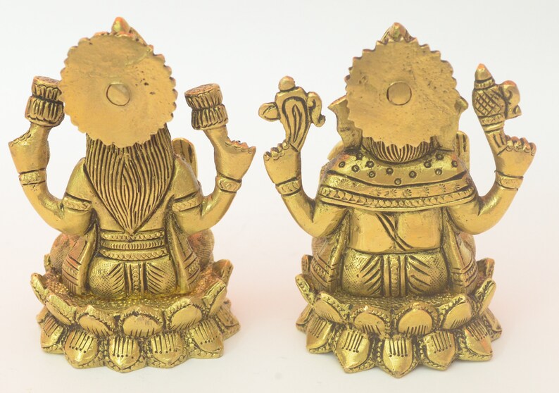 Peut inclure: Deux statues en m&eacute;tal dor&eacute; repr&eacute;sentant les divinit&eacute;s hindoues Lakshmi et Ganesha, assises sur des bases de lotus. Les statues sont finement d&eacute;taill&eacute;es et pr&eacute;sentent un style indien traditionnel.