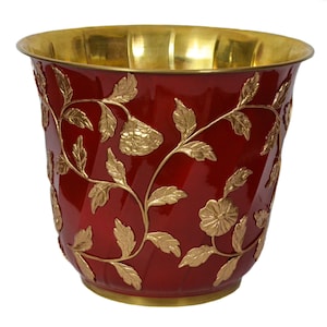 Maceta de latón con diseño en relieve rojo y dorado. Ideal para sala de estar. Diámetro: 30 cm x Alto: 26,5 cm.