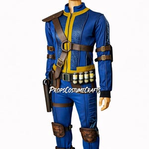 May include: A blue and yellow jumpsuit with a front zipper, featuring brown leather-like straps, buckles, and holsters. The outfit includes knee pads, shin guards, and a belt with small canisters. The text PROPSCOSTUMECRAFTS is visible on the torso.