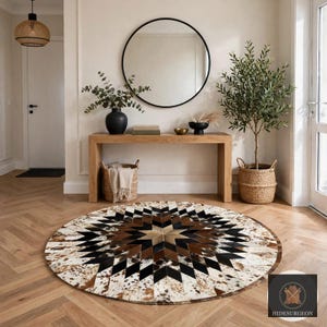 May include: A round cowhide rug featuring a geometric star pattern in shades of brown, black, and white. The rug is composed of stitched leather panels arranged in a radiating design, creating a bold contrast across the circular surface.