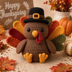 May include: A brown crocheted turkey figurine wearing a black pilgrim hat with a yellow buckle. The turkey has a yellow beak, a red wattle, and a fanned tail featuring layers of orange, red, yellow, and green crocheted feathers with yellow feet.