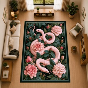 May include: A rectangular area rug featuring a detailed illustration of a pale pink snake coiled among large, blooming pink roses and dark green foliage on a black background, framed by a thin border with small star and crescent moon accents.