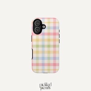 May include: A rectangular mobile phone case featuring a multi-colored pastel plaid pattern with intersecting lines of pink, yellow, blue, and green on a white background. The case has a black camera cutout area in the top left corner.