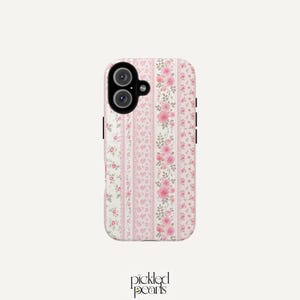 May include: A rectangular phone case featuring a vertical striped pattern of pink roses, green leaves, and delicate white lace-like textures on a light pink background. The case has a black camera module cutout in the upper left corner.