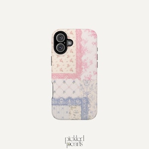 May include: A rectangular phone case featuring a patchwork design of floral and damask patterns in shades of pink, blue, and cream. The case has a black camera cutout area at the top left. The text "pickled pearls" is printed below the case.