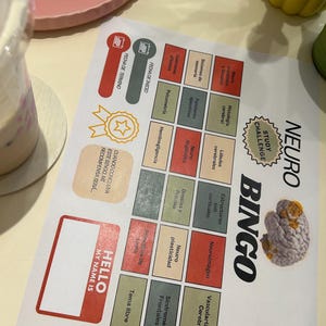 Puede incluir: Una hoja de desafío de estudio Neuro Bingo con una cuadrícula de cuadrados de colores con texto en español que incluye temas como Neuroplasticidad, Histología cerebral y Síndromes frontales, junto a una ilustración de un cerebro y un recuadro Hello My Name Is.