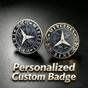 Può includere: Due stemmi circolari Mercedes-Benz con un emblema centrale a stella a tre punte su uno sfondo con motivo a foglie blu e nere. Uno stemma ha un bordo argentato, l'altro un bordo dorato. Il testo Personalized Custom Badge si trova sotto.