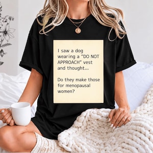 Op de afbeelding: Een zwart t-shirt met korte mouwen en een crèmekleurige rechthoekige afbeelding met de tekst: I saw a dog wearing a DO NOT APPROACH vest and thought... Do they make those for menopausal women?