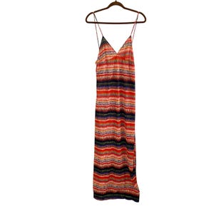 May include: A floor-length maxi dress featuring a vibrant horizontal striped pattern in shades of red, orange, purple, and white. The garment has a V-neckline and thin spaghetti straps, hanging on a brown hanger against a plain white background.