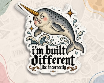 May include: A die-cut sticker featuring a narwhal with a human-like face, a golden horn, and a speckled gray body leaping through blue waves. The text reads, I'M BUILT DIFFERENT like incorrectly, in a bold, black, gothic-style font.