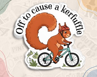 May include: A die-cut sticker featuring a cartoon squirrel with a large bushy tail wearing a red helmet while riding a light blue bicycle. The text "Off to cause a kerfuffle" is arched above the squirrel in black lettering.