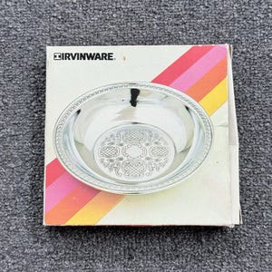 May include: A silver-toned metal bowl with a decorative embossed pattern on the base and a rope-style rim. The bowl is displayed on its original white cardboard packaging box, which features the brand name IRVINWARE and diagonal stripes.