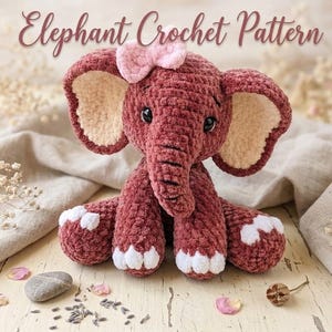 Può includere: Un elefante all'uncinetto di colore rosa scuro con un fiocco rosa chiaro sulla testa, grandi orecchie con sezioni interne color crema e dettagli bianchi sui piedi. Il testo Elephant Crochet Pattern è visualizzato sopra il giocattolo.