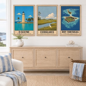 Pu&ograve; includere: Tre stampe artistiche da parete verticali incorniciate con illustrazioni dei parchi nazionali della Florida. La stampa a sinistra mostra il faro di Biscayne, quella centrale le zone umide delle Everglades con un uccello bianco e quella a destra Dry Tortugas.