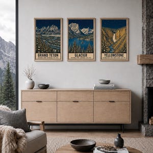 May include: Three vertical framed art prints depicting Grand Teton, Glacier, and Yellowstone National Parks. Each print features a dark blue night sky, snow-capped mountains, evergreen trees, and text identifying the specific national park.