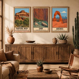 Op de afbeelding: Drie rechthoekige wandposters met illustraties van de nationale parken Capitol Reef, Zion en Arches. Elke print toont een landschap met rode rotsformaties, een blauwe lucht en tekst met de naam van het park en de oprichtingsdatum.