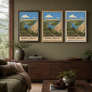 May include: Three vertical wall art prints featuring a landscape illustration of Theodore Roosevelt National Park in North Dakota. The artwork depicts a winding blue river, rocky cliffs, and green trees under a blue sky with white clouds.
