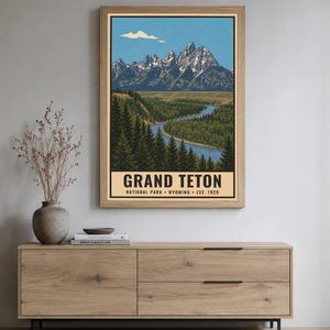 Peut inclure: Une affiche murale verticale repr&eacute;sentant une illustration paysag&egrave;re de la cha&icirc;ne de montagnes Grand Teton avec des sommets enneig&eacute;s, une rivi&egrave;re bleue sinueuse et des for&ecirc;ts de pins denses. Le texte indique GRAND TETON NATIONAL PARK WYOMING EST. 1929.