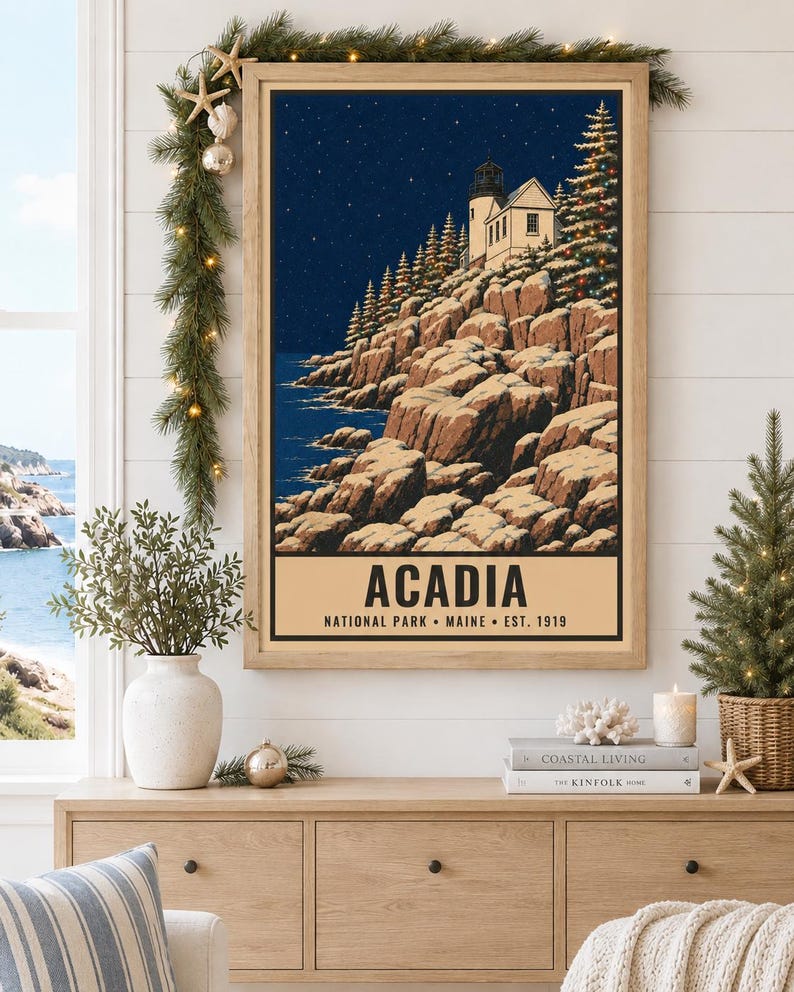 Puede incluir: Un cuadro rectangular enmarcado que muestra una escena costera nocturna con un faro sobre un acantilado rocoso y &aacute;rboles de hoja perenne bajo un cielo estrellado. El texto en la parte inferior dice ACADIA NATIONAL PARK MAINE EST. 1919 en negro.