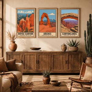 Op de afbeelding: Drie verticale wandkunstprints met illustraties van de nationale parken Bryce Canyon, Arches en Canyonlands in Utah. Elke print toont een landschap met rode rotsformaties, een blauwe lucht en tekst met de naam van het park.