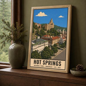 Peut inclure: Une affiche verticale encadr&eacute;e pr&eacute;sentant une illustration d&eacute;taill&eacute;e du parc national de Hot Springs en Arkansas. L'&oelig;uvre repr&eacute;sente des b&acirc;timents historiques, des arbres verts luxuriants et un ciel bleu avec des nuages. Le texte indique HOT SPRINGS NATIONAL PARK ARKANSAS EST. 1921.