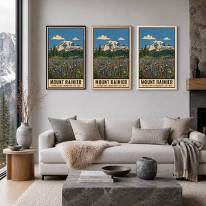 K&ouml;nnte beinhalten: Drei vertikale Wandkunstdrucke mit einer Landschaftsillustration des Mount Rainier, einer bunten Blumenwiese im Vordergrund, blauem Himmel und Wolken. Jeder Druck enth&auml;lt den Text MOUNT RAINIER NATIONAL PARK WASHINGTON EST. 1899.