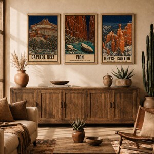 May include: Three vertical art prints featuring illustrations of Capitol Reef, Zion, and Bryce Canyon National Parks in Utah. Each print displays a landscape scene with red rock formations, trees, and starry night skies, with text identifying the park.