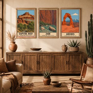 May include: Three rectangular wall art prints featuring illustrations of Capitol Reef, Zion, and Arches National Parks. Each print displays a landscape with red rock formations, blue skies, and text identifying the park name and establishment date.