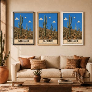 Op de afbeelding: Drie identieke verticale wandkunstprints met een landschap van Saguaro National Park met hoge cactussen, een woestijnbodem en een helderblauwe lucht met wolken. Elke print bevat de tekst SAGUARO NATIONAL PARK ARIZONA EST. 1994.