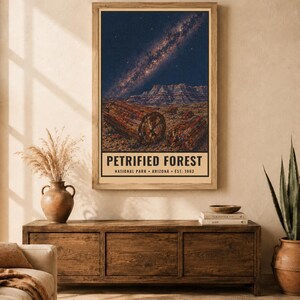 May include: A vertical wall art print featuring a night sky with a visible Milky Way galaxy above a desert landscape with petrified wood logs. The text reads PETRIFIED FOREST NATIONAL PARK ARIZONA EST. 1962 in black lettering on a cream background.