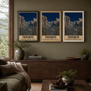 May include: Three vertical wall art prints featuring a nighttime landscape of Yosemite National Park with mountains, a waterfall, and pine trees. The text reads YOSEMITE NATIONAL PARK CALIFORNIA EST. 1890. The prints are displayed in black, wood, and white frames.
