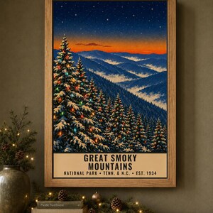 May include: A framed vertical poster depicting the Great Smoky Mountains at twilight. The scene features snow-covered pine trees decorated with colorful lights against a backdrop of blue mountain ridges and a vibrant orange sunset sky.
