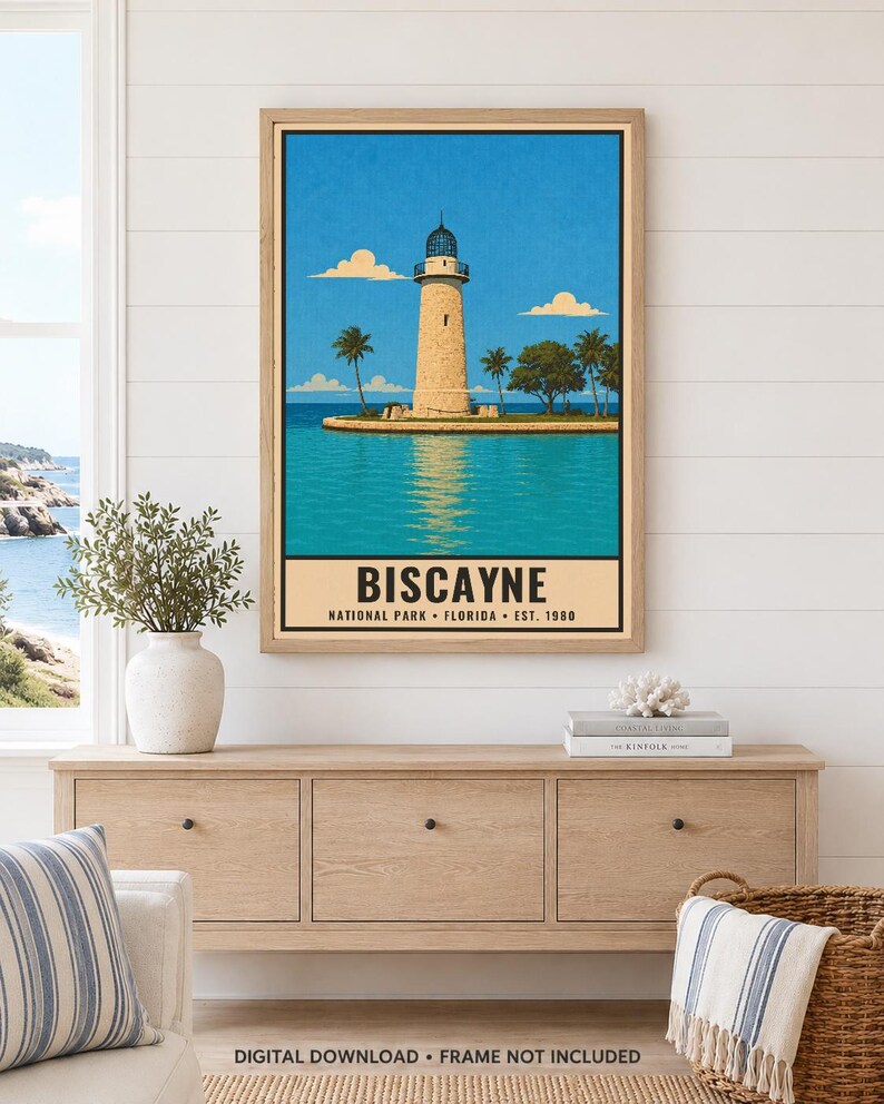 May include: A framed vertical art print featuring a lighthouse on a small island surrounded by turquoise water under a bright blue sky with clouds. The text at the bottom reads BISCAYNE NATIONAL PARK FLORIDA EST. 1980 in a bold black font.