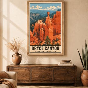 Op de afbeelding: Een verticale wandkunstprint met een gestileerde illustratie van Bryce Canyon National Park in Utah. Het kunstwerk toont oranje rotsformaties, groene dennenbomen en een blauwe lucht. De tekst luidt BRYCE CANYON NATIONAL PARK UTAH EST. 1928.