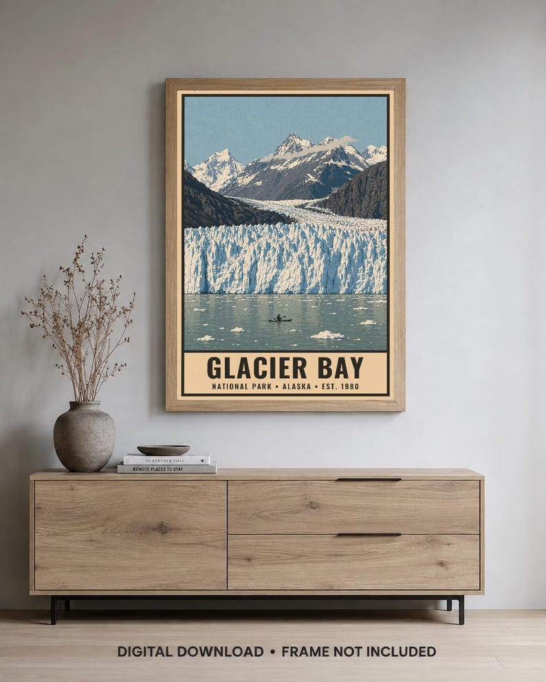 Pu&ograve; includere: Una stampa artistica da parete rettangolare con un paesaggio del Glacier Bay National Park in Alaska. L'immagine mostra montagne innevate, un grande ghiacciaio e un piccolo kayak sull'acqua. Il testo recita GLACIER BAY NATIONAL PARK ALASKA EST. 1980.