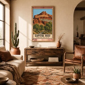 May include: A vertical rectangular wall art print featuring a landscape illustration of Capitol Reef National Park in Utah. The artwork displays red rock formations, green trees, and a blue sky, with the text CAPITOL REEF NATIONAL PARK UTAH EST. 1971.