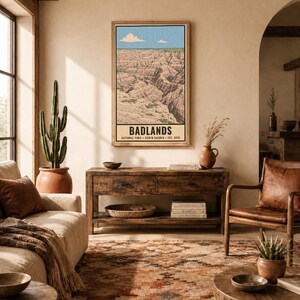 K&ouml;nnte beinhalten: Ein rechteckiger Wandkunstdruck mit einer Landschaftsillustration des Badlands Nationalparks mit geschichteten Felsformationen unter blauem Himmel. Der Text lautet BADLANDS NATIONAL PARK SOUTH DAKOTA EST. 1978. Unten steht DIGITAL DOWNLOAD FRAME NOT INCLUDED.
