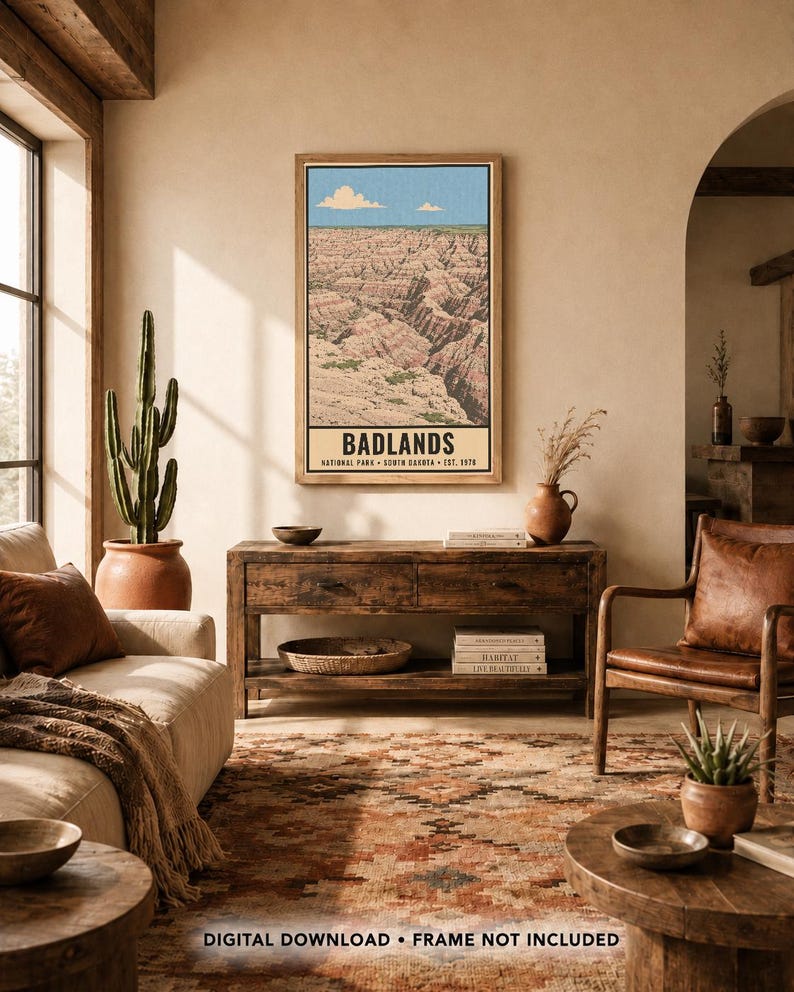 K&ouml;nnte beinhalten: Ein rechteckiger Wandkunstdruck mit einer Landschaftsillustration des Badlands Nationalparks mit geschichteten Felsformationen unter blauem Himmel. Der Text lautet BADLANDS NATIONAL PARK SOUTH DAKOTA EST. 1978. Unten steht DIGITAL DOWNLOAD FRAME NOT INCLUDED.