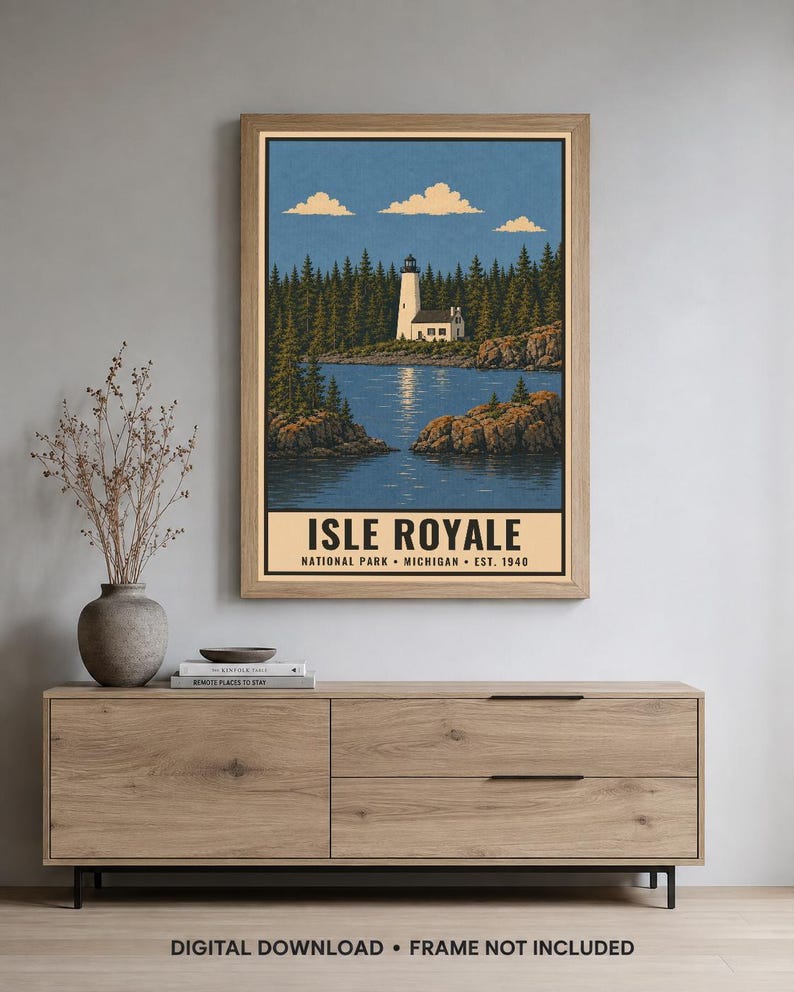 Op de afbeelding: Een verticale poster met een witte vuurtoren op een rotsachtige kustlijn, omringd door een dicht bos en blauw water onder een heldere lucht. De tekst onderaan luidt ISLE ROYALE NATIONAL PARK MICHIGAN EST. 1940 in vetgedrukte zwarte letters.