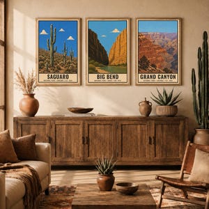May include: Three framed vertical wall art prints depicting Saguaro, Big Bend, and Grand Canyon National Parks. Each print features a landscape illustration with a blue sky, white clouds, and the park name printed in black text at the bottom.