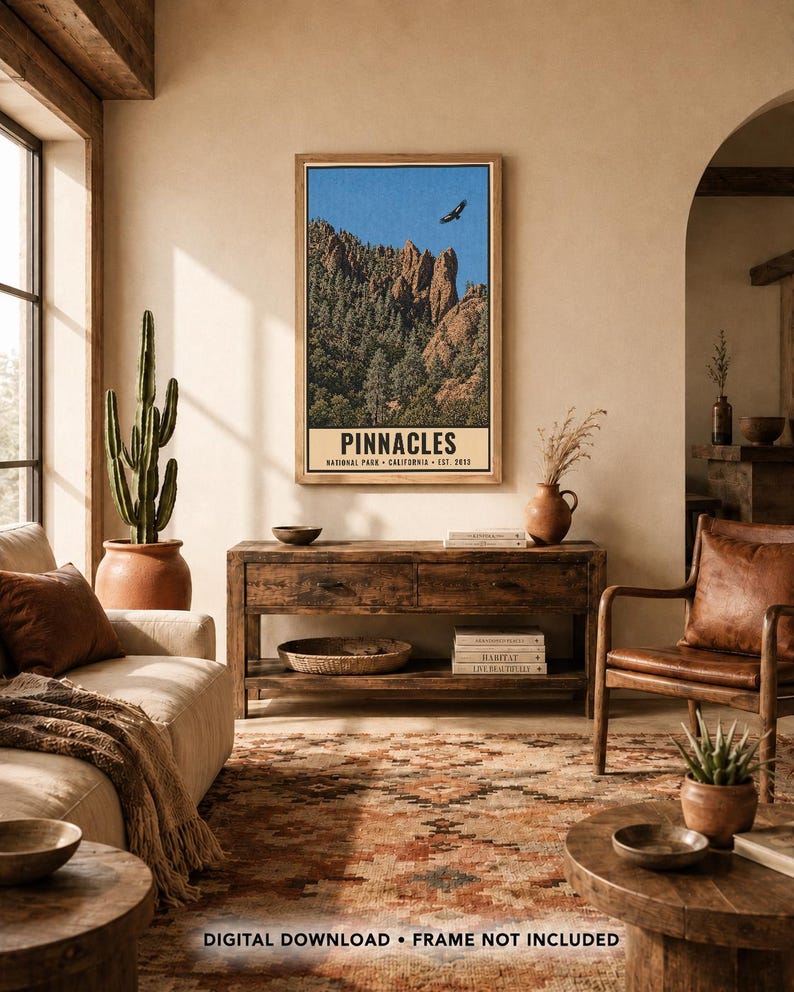 Op de afbeelding: Een verticale rechthoekige wandkunstprint met een landschap van Pinnacles National Park, Californi&euml;, met rotsachtige pieken, groene bomen, een blauwe lucht en een vliegende vogel. De tekst luidt PINNACLES NATIONAL PARK CALIFORNIA EST. 2013.