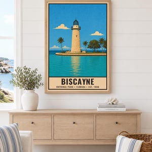 Pu&ograve; includere: Una stampa artistica verticale incorniciata raffigurante un faro su una piccola isola circondata da acqua turchese sotto un cielo azzurro brillante con nuvole. Il testo in basso recita BISCAYNE NATIONAL PARK FLORIDA EST. 1980 in grassetto.