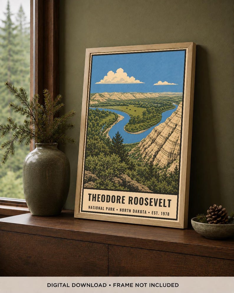 May include: A framed vertical art print depicting a landscape of Theodore Roosevelt National Park in North Dakota. The illustration features a winding blue river through green terrain and tan cliffs under a blue sky with white clouds. Text reads: THEODORE ROOSEVELT NATIONAL PARK &bull; NORTH DAKOTA &bull; EST. 1978.